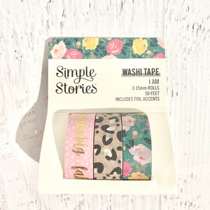 May include: A set of three 15mm washi tape rolls from Simple Stories. The tapes feature a pink floral design with gold foil accents, a leopard print, and a green floral design. The packaging includes the text "Washi Tape", "I AM", "3 15mm ROLLS", "50 FEET", and "INCLUDES FOIL ACCENTS".