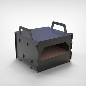May include: A black, rectangular pet bed with a handle on top. The bed has a rectangular opening on the front and a brown interior. The bed is made of a dark material and sits on a white surface.