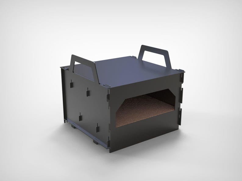 May include: A black, rectangular pet bed with a handle on top. The bed has a rectangular opening on the front and a brown interior. The bed is made of a dark material and sits on a white surface.