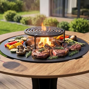 May include: A round wooden outdoor dining table with a built-in grill and a central fire pit. The grill holds grilled vegetables and steaks. Two glasses of red wine sit on the table.