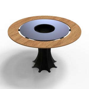 May include: A round table with a light brown wooden rim and a dark gray center. The table has a black, stylized pedestal base. The table's diameter is approximately 40 inches.