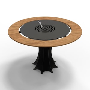 May include: A round outdoor grill table with a wooden rim and a black metal center. The table has a black, stylized base. A small, silver utensil rests on the grill surface.