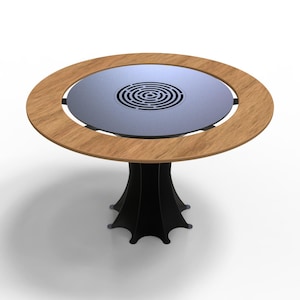 May include: A round table with a light wood-colored rim and a dark gray center with a spiral design. The table has a black, stylized base. The table is suitable for indoor use.