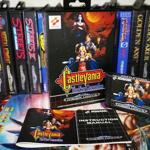 Può includere: Una collezione di cartucce e scatole di videogiochi Sega Mega Drive, tra cui "Castlevania: The New Generation". La scatola del gioco presenta opere d'arte di personaggi con uno sfondo scuro. Sono inclusi anche la cartuccia del gioco e il manuale di istruzioni.