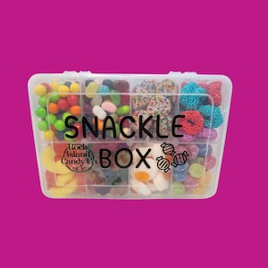 May include: A clear plastic snack box filled with a variety of colorful candies. The box is divided into compartments, each holding different types of sweets, including jelly beans, gummy candies, and candies with sprinkles. The text "SNACKLE BOX" is printed on the box.