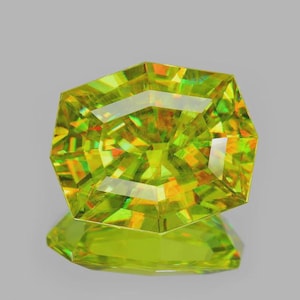May include: A faceted, radiant-cut gemstone in a vivid yellow-green shade. The gem's many facets reflect light, producing a dazzling display of colour and brilliance. The gemstone is set against a neutral background, highlighting its clarity and cut.