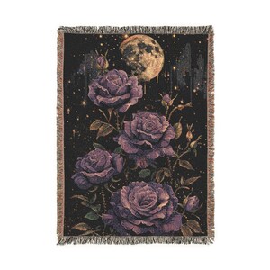 May include: Woven throw blanket featuring a dark background with a large, full moon and falling stars. The design includes several large, purple roses with green leaves. The blanket has a fringed edge.