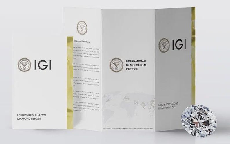 May include: A brilliant-cut diamond next to a white brochure with the IGI logo and text. The brochure is labeled "Laboratory Grown Diamond Report" and "International Gemological Institute". The diamond is round and faceted.