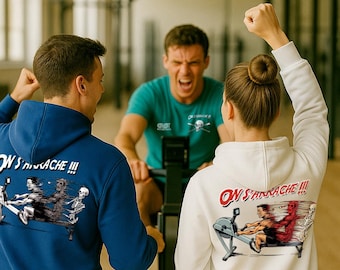 May include: A group of people in a gym setting, wearing hoodies with graphic designs. The hoodies are blue and white, with the text "ON S'ARRÂCHE !!!" and illustrations of people rowing. One person is rowing on a machine.