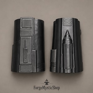 May include: Two matte black forearm guards featuring intricate geometric paneling and raised structural details. The left guard displays rectangular segments, while the right guard features a central conical protrusion and a textured grid pattern.