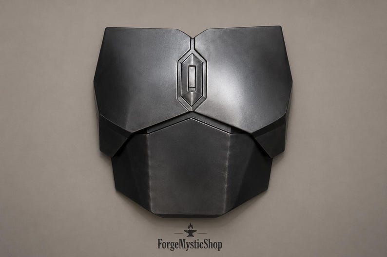 May include: A matte black chest plate armor piece featuring a geometric, multi-panel design with a central vertical rectangular emblem. The armor has a smooth, dark finish with sharp, angular edges and a symmetrical construction across the front.