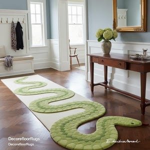 May include: A long, rectangular rug featuring a green snake design. The snake's body is a lighter green with darker green scales. The rug is placed on a wooden floor in a hallway. The text "DecorefloorRugs" is visible.