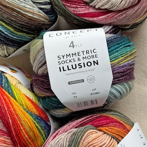 Puede incluir: Primer plano de varios ovillos de hilo colorido. El hilo está etiquetado como "SYMMETRIC SOCKS & MORE ILLUSION" y es una mezcla de 4 cabos. Los colores incluyen tonos de azul, verde, rojo, naranja y morado. Cada ovillo pesa aproximadamente 80 gramos.