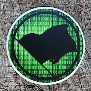 May include: A black and green sticker with a black flag and a circle of green binary code around it.