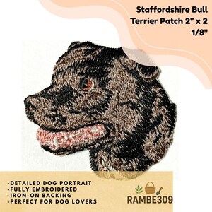 May include: Embroidered Staffordshire Bull Terrier patch, approximately 2 inches by 2 1/8 inches. The patch features a detailed dog portrait in shades of brown and black, with a pink mouth. The patch has iron-on backing.