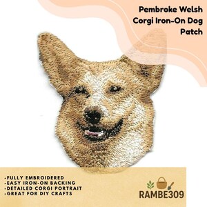 May include: An embroidered iron-on patch featuring the head of a Pembroke Welsh Corgi with tan and white fur. The dog has pointed ears, dark eyes, and a black nose. The patch displays detailed stitching to represent the texture of the dog's coat.