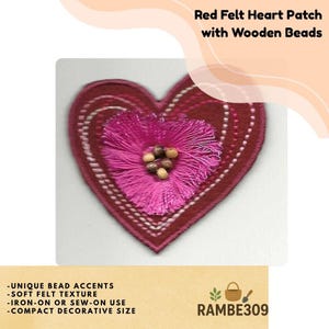 May include: A red felt heart patch with wooden beads and a soft felt texture. The patch features a central pink floral design with wooden bead accents. The text "Red Felt Heart Patch with Wooden Beads" is at the top.