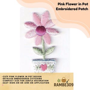 May include: Embroidered patch featuring a pink flower in a pot. The flower has pink petals and a dark pink center. The pot is light blue with a pink heart design. The patch is designed for iron-on or sew-on application.