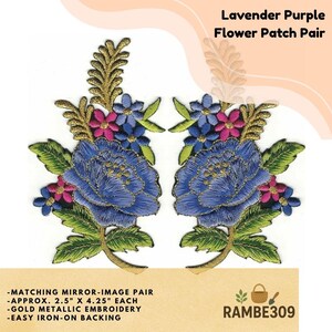 May include: A pair of mirror-image embroidered flower patches featuring lavender purple and blue petals, green leaves, and gold metallic thread accents. Each patch measures approximately 2.5 inches by 4.25 inches with iron-on backing.