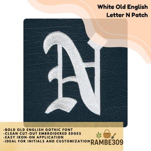 May include: White Old English letter N patch. The patch features a white embroidered letter N in a bold Old English Gothic font on a dark blue background. The patch has clean cut-out embroidered edges and is easy to iron on.