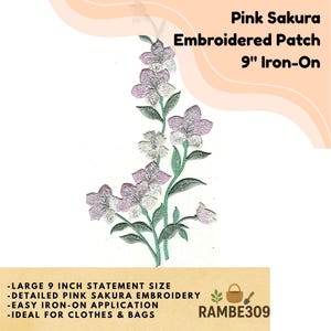 May include: Pink Sakura embroidered patch, 9-inch iron-on. The patch features a detailed design of pink and white sakura blossoms with green stems and leaves. The text on the patch reads: "Pink Sakura Embroidered Patch 9" Iron-On".
