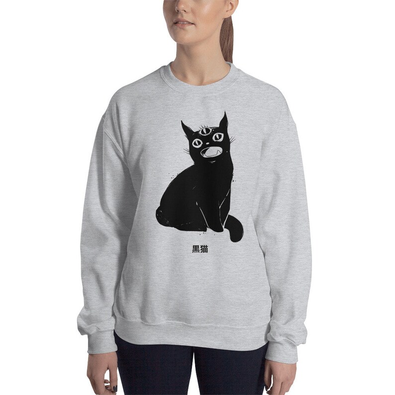 May include: A gray sweatshirt with a black cat illustration. The cat has three eyes and an open mouth. The text "黒猫" is printed below the cat.