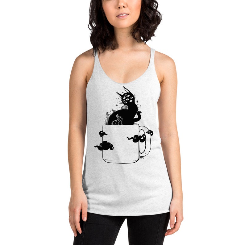 Pu&ograve; includere: Un top bianco a spalline con un'illustrazione in bianco e nero di un gatto con pi&ugrave; occhi seduto in una tazza da caff&egrave;. Il gatto &egrave; circondato da nuvole.