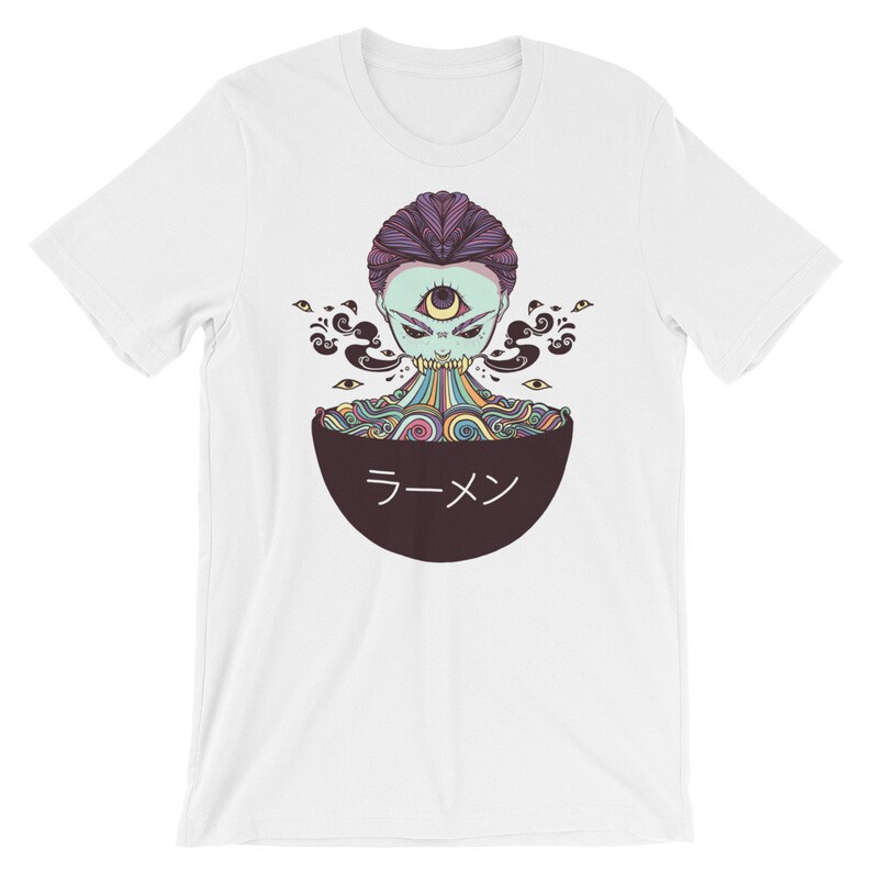 Peut inclure: T-shirt blanc avec un motif repr&eacute;sentant un personnage psych&eacute;d&eacute;lique color&eacute; avec un troisi&egrave;me &oelig;il, consommant un bol de ramen. Le bol est noir avec le mot "ラーメン" en blanc.