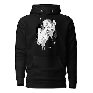 May include: Black hoodie featuring a white graphic of two wolf heads with multiple eyes and a dripping tongue. The graphic is centred on the hoodie.