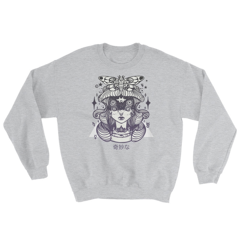 May include: A gray sweatshirt with a black and white illustration of a woman with a moth on her head. The woman has multiple eyes and is surrounded by stars. The text "香妙な" is printed below the illustration.