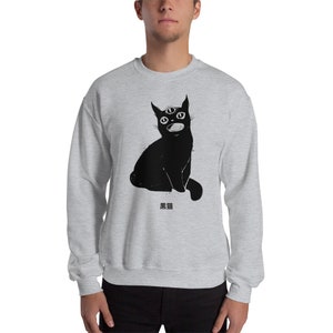 May include: A grey sweatshirt with a black cat illustration. The cat has three eyes and is sitting with its mouth open. The Japanese text "黒猫" is printed below the cat.