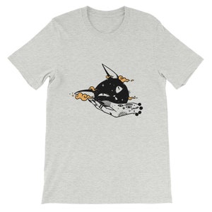 May include: A grey t-shirt with a black and white illustration of a cat's head with stars and a hand with a tattoo.