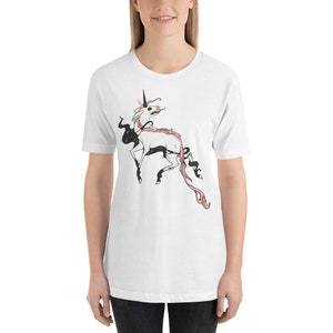 May include: White t-shirt with a black and pink illustration of a unicorn with a star on its side.