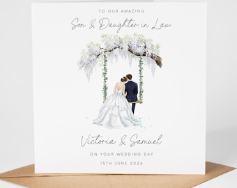 May include: A white wedding card with a watercolor illustration of a couple on a swing under a flowering tree. The card reads "To Our Amazing Son & Daughter in Law" and includes the names "Victoria & Samuel" and the date "15th June 2026".