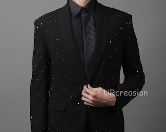 May include: A black suit, shirt, and tie ensemble. The jacket features a shawl collar and is adorned with small, dark studs. The outfit is formal and stylish, suitable for special occasions.