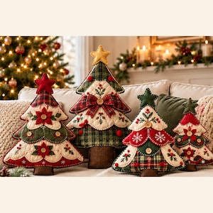 May include: Four quilted fabric Christmas tree decorations in varying sizes. Each tree features a brown trunk, a star topper, and layers of green, red, and cream fabric with embroidered floral details, plaid patterns, and small wooden buttons.