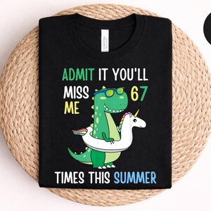 May include: Black t-shirt with a graphic of a green dinosaur wearing sunglasses and a unicorn in a floatie. Text reads "ADMIT IT YOU'LL MISS ME 67 TIMES THIS SUMMER" in green, yellow, and blue.
