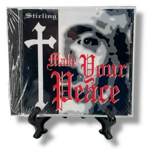 May include: A CD case with the title "Make Your Peace" in red gothic lettering. The CD cover features a black and white image of a face and a white cross on a black background. The artist's name, "Stirling", is at the top.