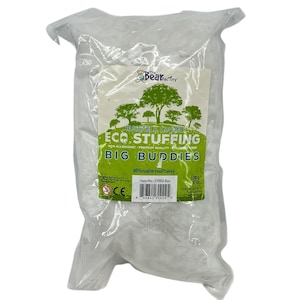 May include: A clear plastic bag filled with white stuffing. The label reads "HUGGABLE, LOVABLE ECO STUFFING" and "BIG BUDDIES". The Bear Factory logo is at the top. The bag contains 170 g (6 oz) of stuffing.