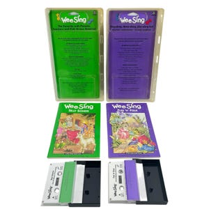 May include: Two Wee Sing audio cassette and songbook sets in green and purple packaging. Each set includes a plastic-cased cassette tape and a illustrated songbook titled Silly Songs or Fun 'N' Folk, featuring musical notes and text details.