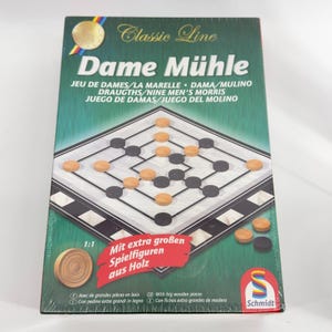 May include: A board game box for Dame Mühle featuring a green background with a game board illustration, black and light wood game pieces, and text including Classic Line, Dame Mühle, and Mit extra großen Spielfiguren aus Holz.