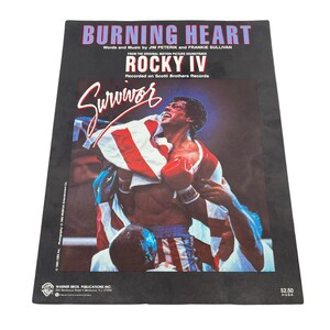 May include: A promotional poster for the Rocky IV soundtrack, featuring the song "Burning Heart." The poster displays the film's title and the word "Survivor" in a stylized font. The image shows a boxer holding an American flag.