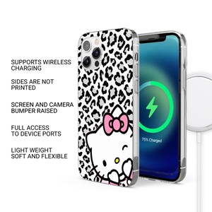 May include: A clear phone case with a black and white leopard print design and a Hello Kitty graphic. The case supports wireless charging, has raised screen and camera bumpers, and full access to device ports. The phone screen shows a charging symbol.