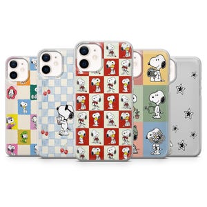 May include: A collection of five phone cases featuring Snoopy designs. The cases display various patterns, including checkerboard, floral, and Snoopy illustrations. Colors include red, blue, yellow, and gray. Each case has a clear border.