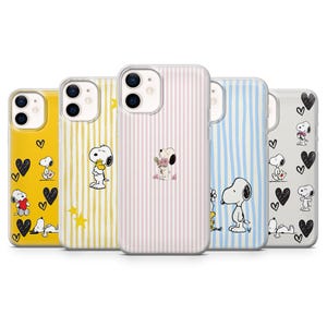 May include: Five phone cases with Snoopy designs. The cases feature Snoopy with hearts, flowers, and stars. The cases have yellow, pink, blue, and white striped backgrounds. The cases are designed for a smartphone.