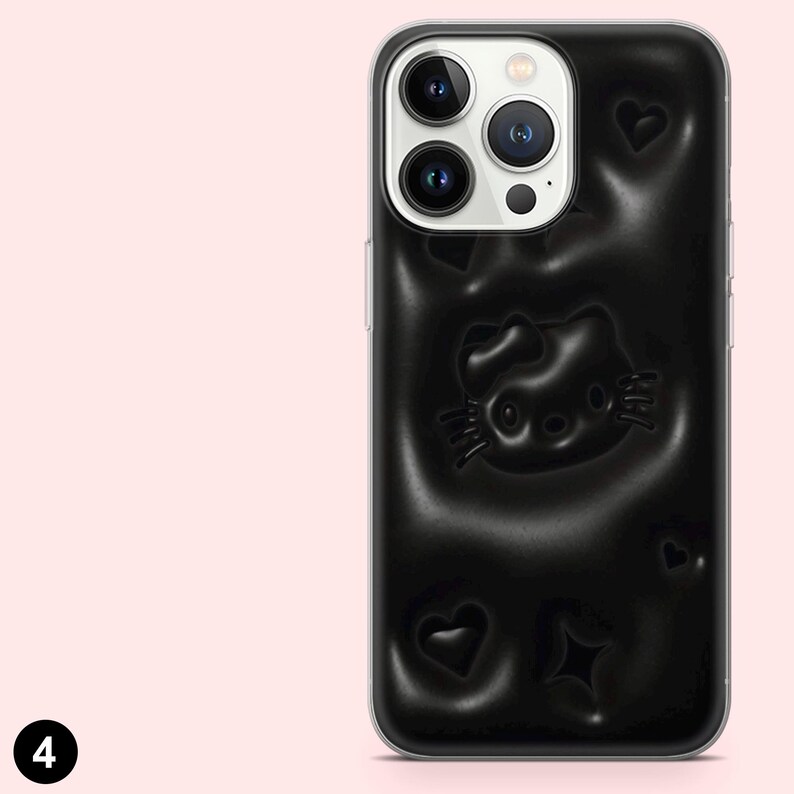 May include: Black smartphone case featuring a raised Hello Kitty design, hearts, and a star. The case has a glossy finish and is designed to fit a smartphone. The case is black with a clear border.