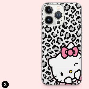 May include: A clear phone case with a black and white leopard print pattern. The case features a white cartoon cat with a pink bow. The phone case has a camera cutout and a black number 3 in the bottom left corner.