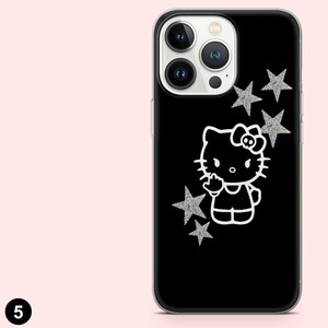 Op de afbeelding: Zwarte telefoonhoes met een wit cartoon kat ontwerp en zilveren glitter sterren. De hoes heeft een transparante rand en een uitsparing voor de camera. Het ontwerp is een populair stripfiguur.