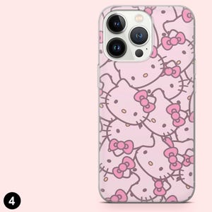 May include: A pink phone case featuring a repeating pattern of Hello Kitty faces with pink bows. The case has a clear border and a camera cutout. The background is a solid light pink color.