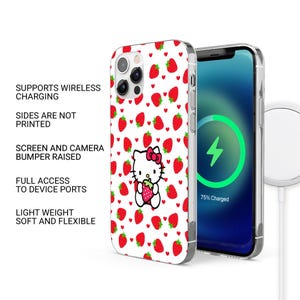 以下が含まれることがあります： イチゴとハローキティのデザインが施された白い携帯電話ケース。ケースは透明な縁があり、充電中の電話と一緒に表示されます。ケースはワイヤレス充電をサポートし、デバイスポートへのフルアクセスが可能です。